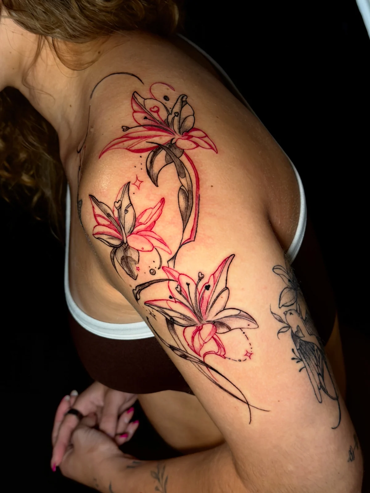 Red and black floral shoulder tattoo by Jessica
