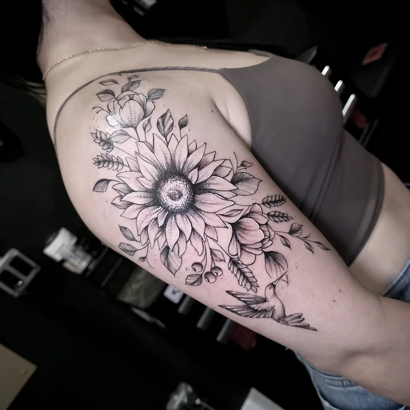 Fine line floral upper-arm tattoo by Rody